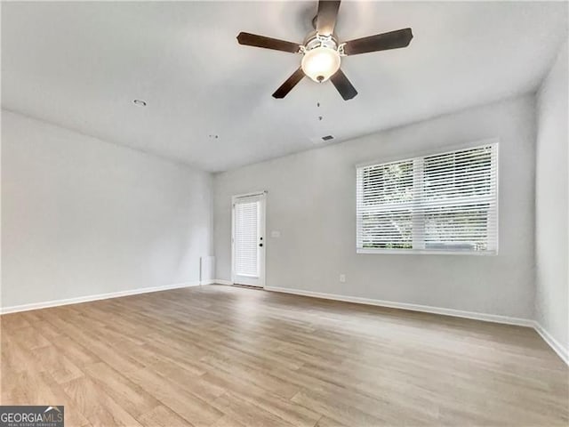 empty room with ceiling fan and light hardwood / wood-style floors