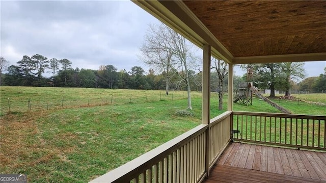 wooden deck featuring a lawn and a rural view