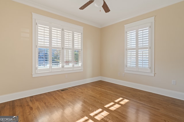 empty room featuring ceiling fan, wood-type flooring, and crown molding