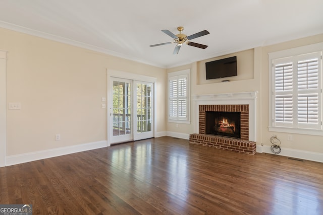 unfurnished living room with a fireplace, dark hardwood / wood-style floors, ceiling fan, and crown molding