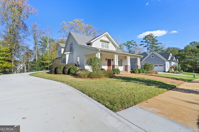 view of front of house with a front lawn, covered porch, and a garage