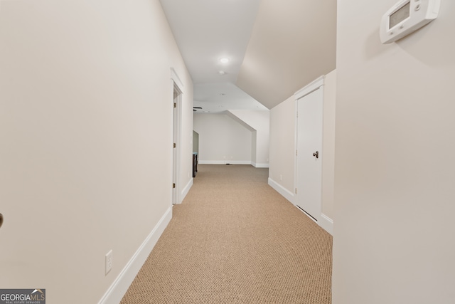 corridor with light colored carpet and lofted ceiling