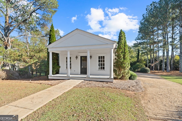 neoclassical home featuring covered porch and a front yard