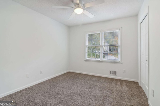 unfurnished bedroom featuring ceiling fan, carpet, and a textured ceiling