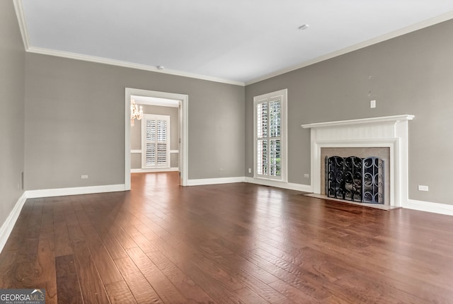 unfurnished living room featuring dark hardwood / wood-style floors, ornamental molding, and a notable chandelier