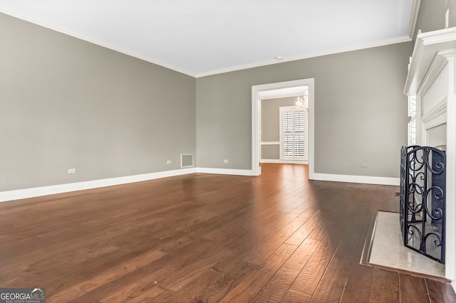 unfurnished living room featuring dark hardwood / wood-style flooring, a notable chandelier, and ornamental molding