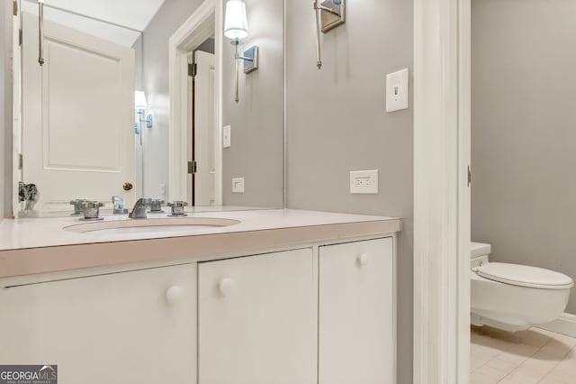 bathroom with toilet, vanity, and tile patterned floors