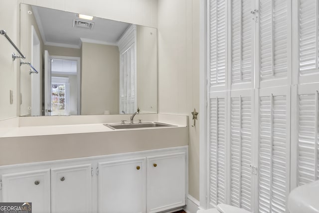 bathroom with vanity, toilet, and crown molding