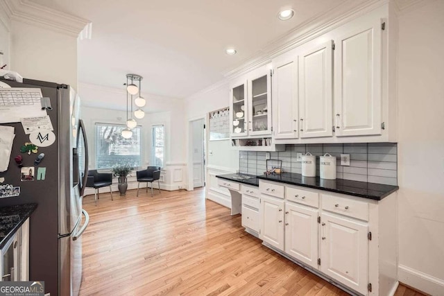 kitchen featuring stainless steel fridge, white cabinetry, light hardwood / wood-style floors, and decorative light fixtures