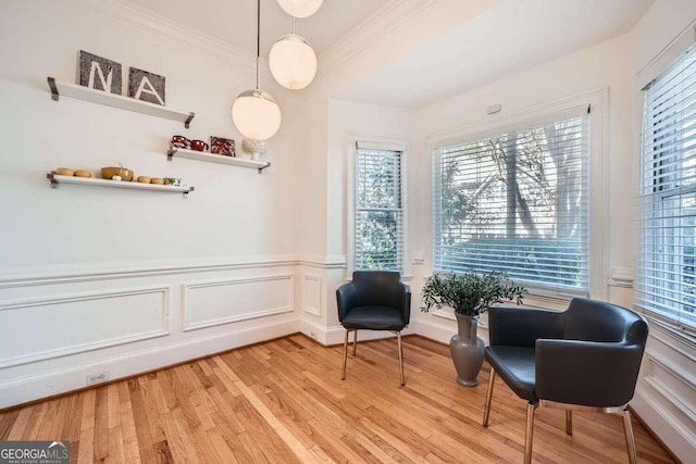 living area featuring ornamental molding, a healthy amount of sunlight, and hardwood / wood-style flooring