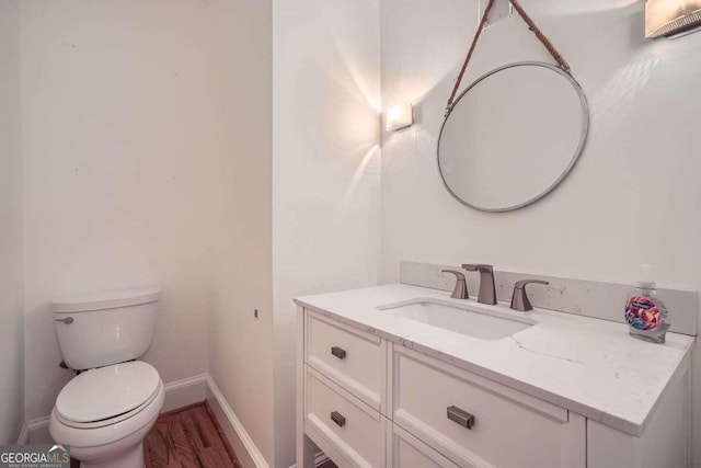 bathroom featuring hardwood / wood-style floors, vanity, and toilet