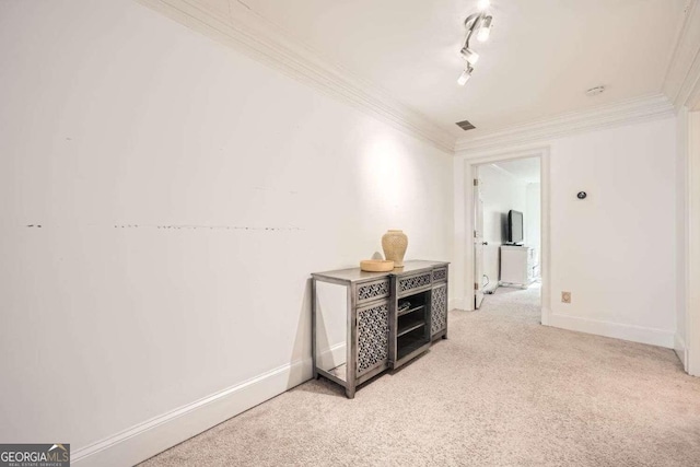 hallway featuring light carpet, rail lighting, and crown molding