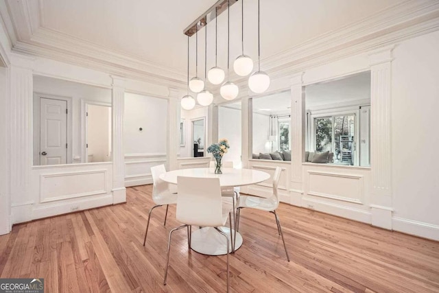 dining space featuring a notable chandelier, light hardwood / wood-style floors, and crown molding