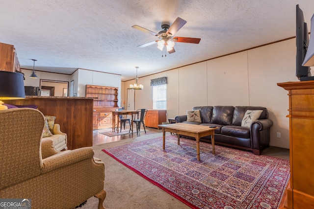 living room featuring ceiling fan with notable chandelier, carpet, and a textured ceiling