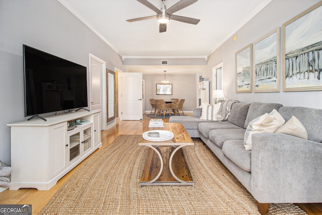 living room featuring ceiling fan, crown molding, and light hardwood / wood-style flooring