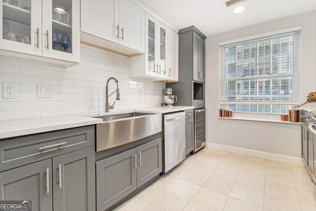 kitchen with sink, wine cooler, stainless steel dishwasher, decorative backsplash, and gray cabinets