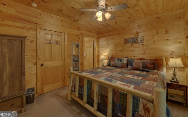 carpeted bedroom featuring ceiling fan, wood walls, and wooden ceiling