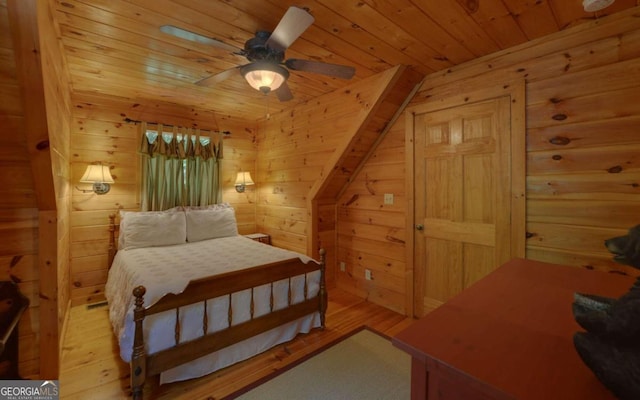 bedroom featuring wood walls, ceiling fan, light hardwood / wood-style floors, and wood ceiling