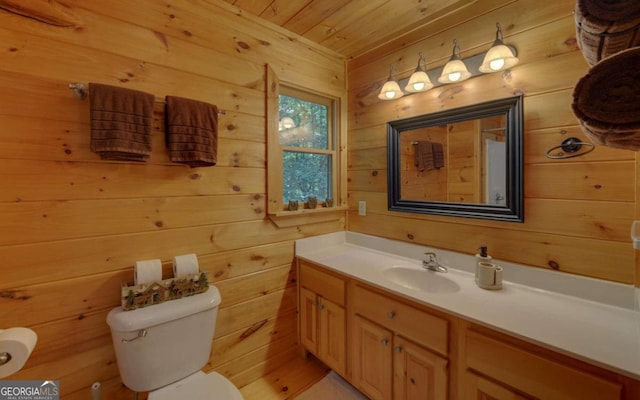 bathroom featuring wooden walls, vanity, wood ceiling, and toilet