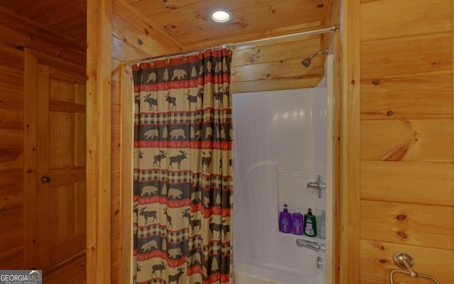 bathroom with shower / bath combination with curtain, wooden walls, and wood ceiling