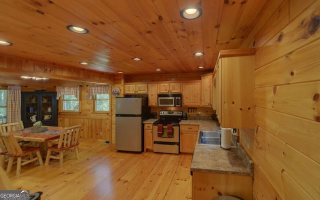 kitchen featuring light wood-type flooring, stainless steel appliances, light brown cabinets, wooden ceiling, and wood walls