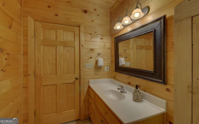 bathroom featuring vanity and wood walls