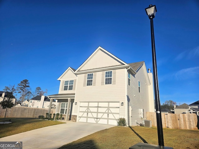 view of front property featuring central AC, a garage, and a front lawn