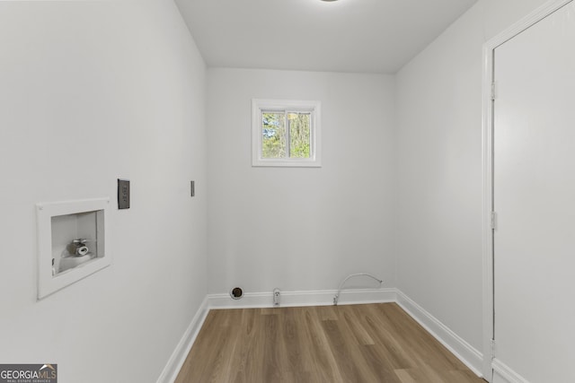 laundry area with laundry area, baseboards, washer hookup, and wood finished floors