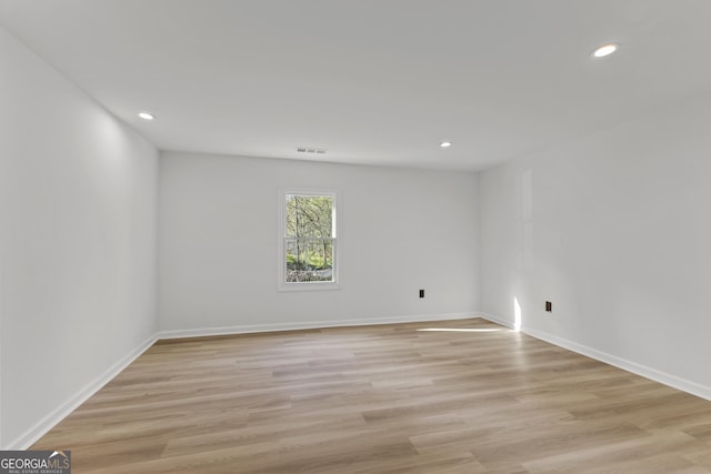 spare room with baseboards, light wood-style flooring, and recessed lighting