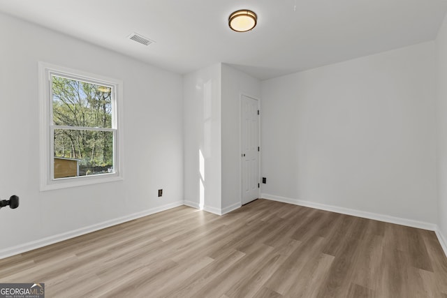 spare room with light wood-style floors and baseboards