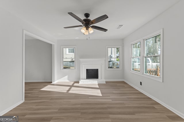 unfurnished living room featuring baseboards, a brick fireplace, visible vents, and light wood-style floors