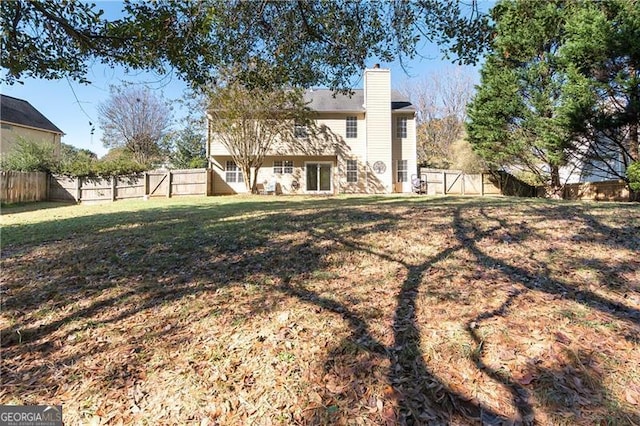 back of house featuring a lawn