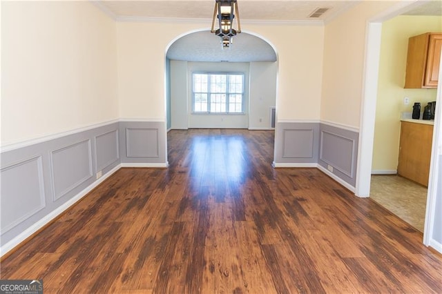 unfurnished dining area featuring dark hardwood / wood-style floors and crown molding