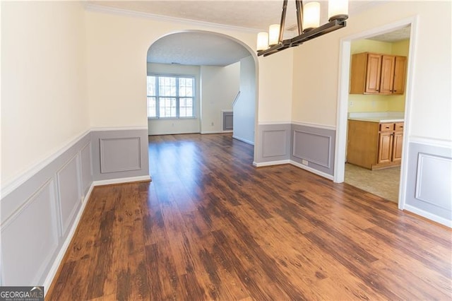 unfurnished dining area featuring crown molding, dark wood-type flooring, and a textured ceiling