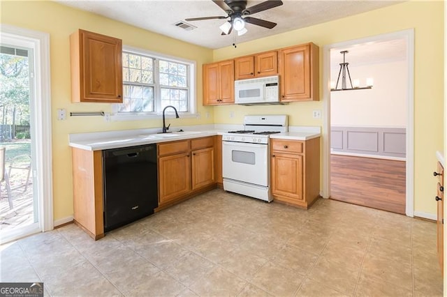 kitchen featuring a wealth of natural light, white appliances, hanging light fixtures, and sink