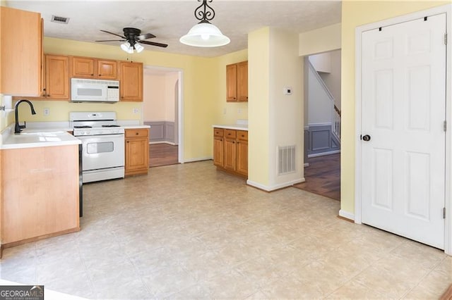 kitchen with ceiling fan, white appliances, hanging light fixtures, and sink