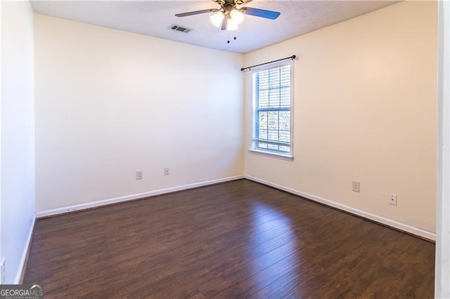 spare room featuring dark hardwood / wood-style floors and ceiling fan