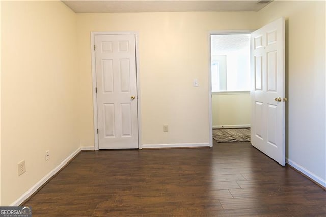 unfurnished bedroom with dark hardwood / wood-style floors