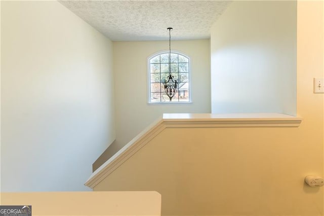 stairway featuring a textured ceiling