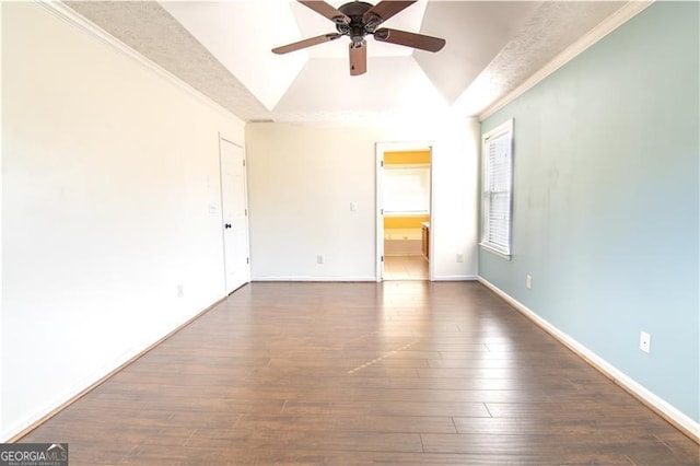 empty room featuring ceiling fan, dark wood-type flooring, lofted ceiling, and ornamental molding