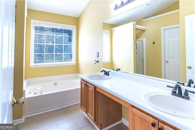 bathroom with tile patterned floors, vanity, vaulted ceiling, and a bathtub