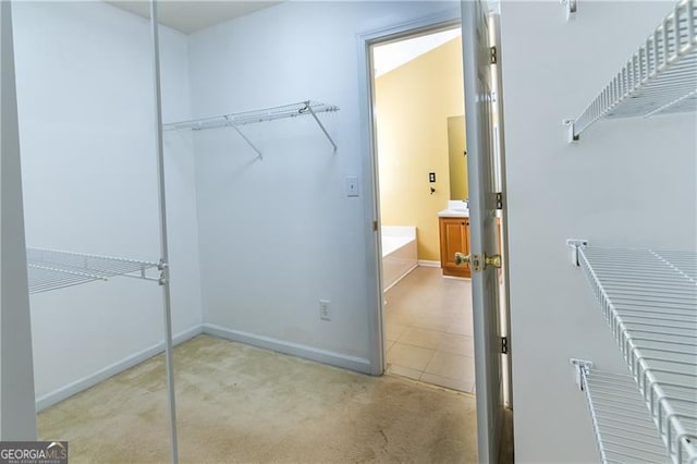 walk in closet featuring light carpet