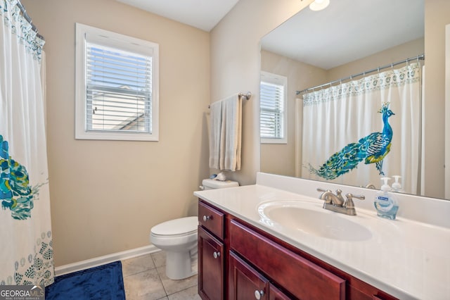 bathroom featuring toilet, vanity, tile patterned floors, and a wealth of natural light