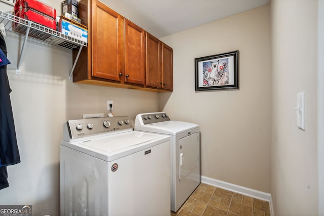 laundry room featuring washer and dryer and cabinets