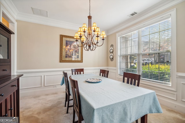 dining space with crown molding, light carpet, and an inviting chandelier