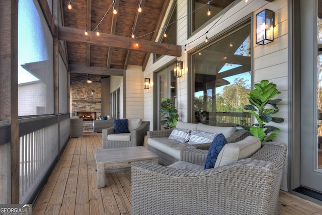 wooden deck featuring an outdoor stone fireplace