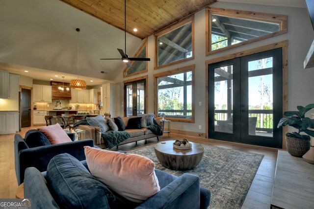 living room featuring french doors, light hardwood / wood-style flooring, high vaulted ceiling, and plenty of natural light