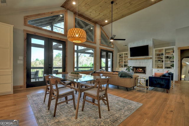 dining space with wood ceiling, light hardwood / wood-style flooring, high vaulted ceiling, and french doors