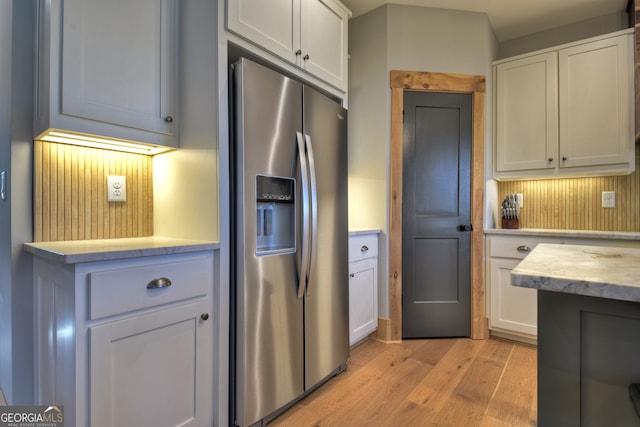 kitchen featuring white cabinetry, stainless steel fridge, and light hardwood / wood-style floors