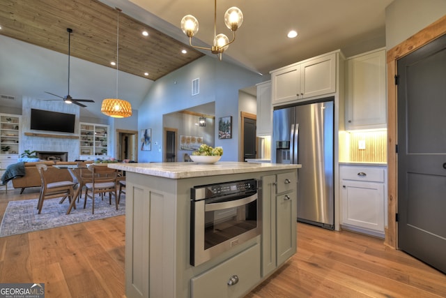 kitchen with white cabinets, a center island, high vaulted ceiling, and stainless steel appliances